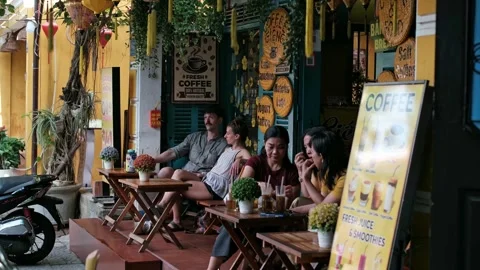 People relaxing and drinking iced coffee at an outdoor street cafe counter Stock Footage 337421083