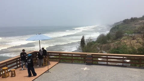 People Relaxing on a Cliffside Viewpoint Deck Overlooking the Ocean Видео 347015916