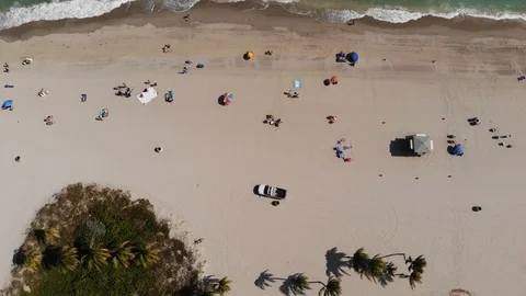 People relaxing on ocean beach at summertime. View from the top Stock Footage 97699633