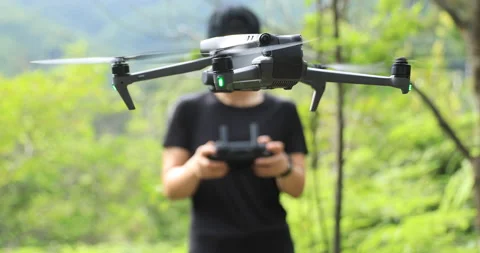 People remote control a flying drone in summer forest Stock Footage 197514370