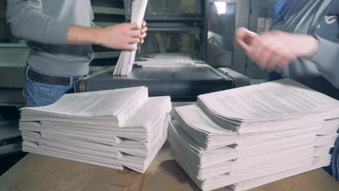 People remove piles of paper from a typographic conveyor. Stock Footage 105804573