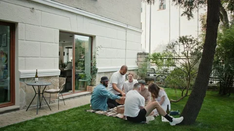 People rest in yard and man brings boxes with board games Stock Footage 219952637