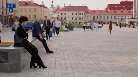People resting on a bench and using smartphones in a historic european city Stock Footage 324720057