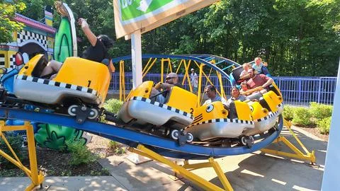 People ride a small roller coaster in Toronto. Stock Photos