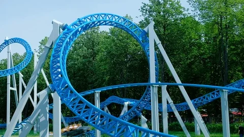 People ride upside-down circle on blue roller coaster Stock Footage 113086542