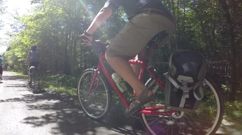 People riding bikes through a beautiful green forest Stock Footage