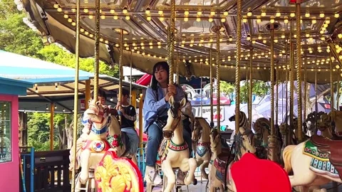 People riding a carousel at a theme park in Gwacheon, South Korea Stock Footage 289390257