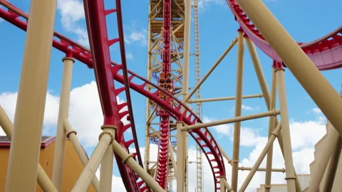 People Riding On crazy Roller Coaster In Amusement Park against blue sky Video stock 143647709