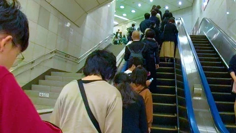 People riding the escalator inside the subway in Osaka Japan Stock Footage 129278610