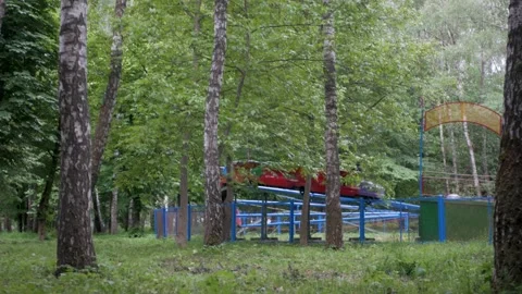 People riding on an old half-empty authentic soviet rollercoaster in local park Vidéo 197336098