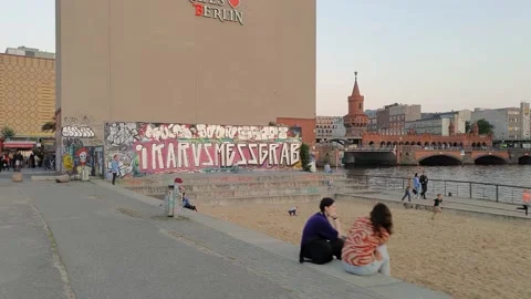 People at riverside during sunset. Oberbaum Bridge on background. Stock Footage 169690868