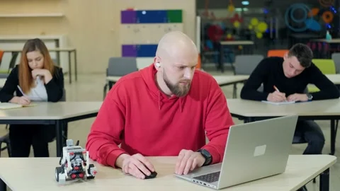 People at the robotics lessons, writting important things and trying to do the Stock Footage 156048906