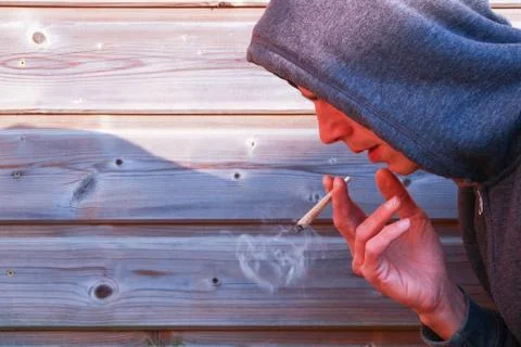 People with a rolled cigarette with a wrinkled hand. Stock Photos