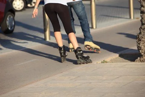 People rollerblading down a sidewalk Stock Photos