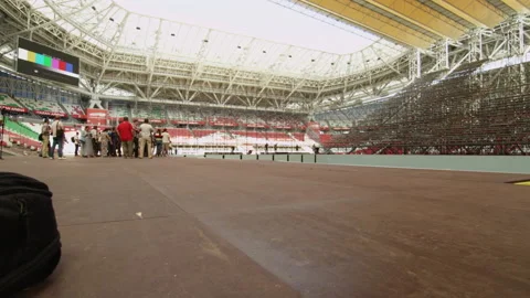 People on roundabout path observe construction of stadium Stock Footage 234426026