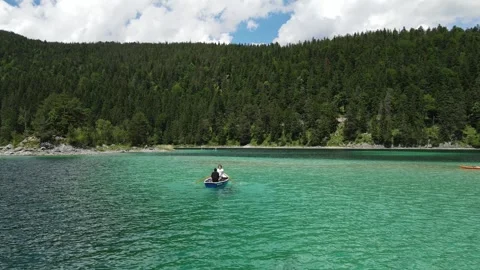 People rowing boat on Eibsee alpine lake near Zugspitze, Bavarian Alps, Germany Stock Footage 328350520