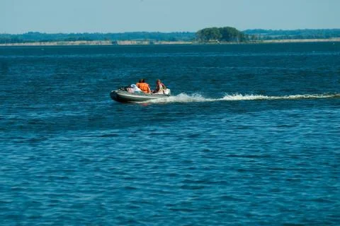 People in rubber boat with motor float Stock Photos