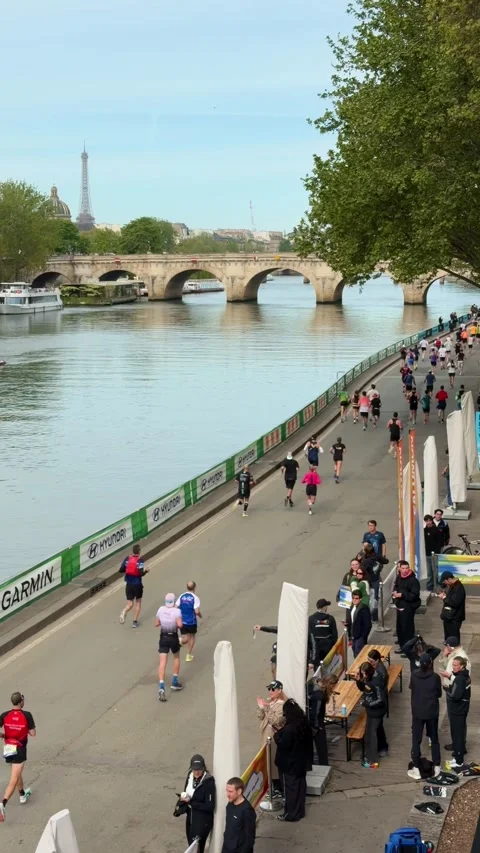 People running the Paris marathon along the Seine river with the Eiffel Tower Stock Footage 337024196