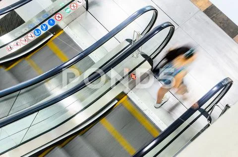 People rush on escalator motion blurred Stock Photos