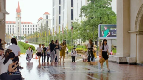 People rush through gate in Assumption University (ABAC) on rainy day Vidéo 112671431