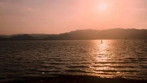 People sailing through Timah Tasoh Lake when sunset reflection in the lake. Stock Footage