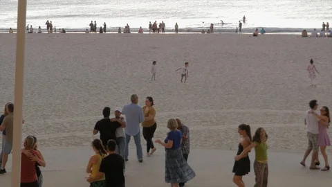 People salsa dancing on the beach at sunset Stock Footage 127367515
