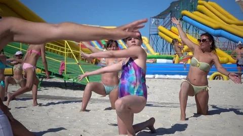 People on the Sea Summer Beach dancing in Swimsuits do gymnastics exercises Stock Footage