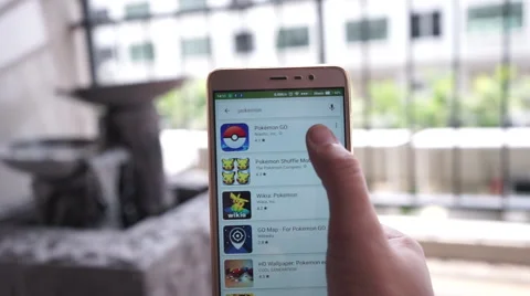 People searching for Pokemon GO in Google Play Store and install on smartphone Stock Footage 66234792