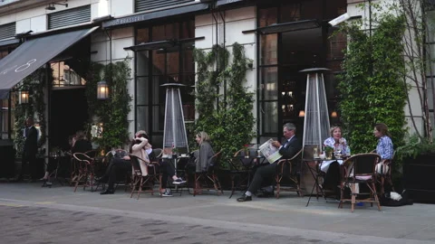 People seating dining and drinking coffee outdoor restaurant in London Stock Footage 146233038