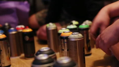 People selecting spray paint cans indoors Stock Footage 317254319