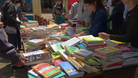 People sell and buy second hand and new textbooks at discounts in the street Stock Footage