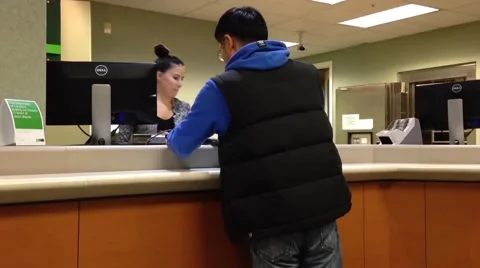 People at a service counter talking to the teller Stock-Footage 44408845