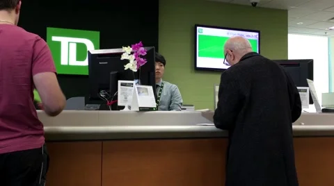 People at service counter talking to the teller inside TD Bank 스톡 동영상 61574155