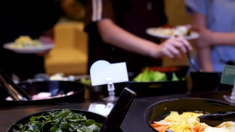 People Serving Fresh Greens at Self-Service Salad Bar Stock Footage 325299562