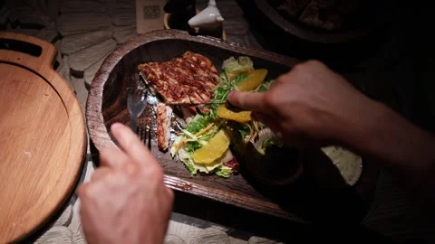 People share and cut steak at a lively dinner table with assorted dishes Stock Footage 344744568
