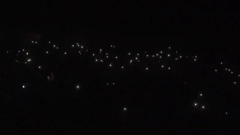People shining flashlights. Crowd of people shining screens of telephones. Co Stock-Footage 78556489