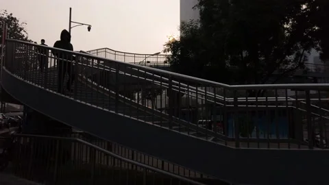 People in silhouette walking down from overpass in the morning. Stock Footage 142641465