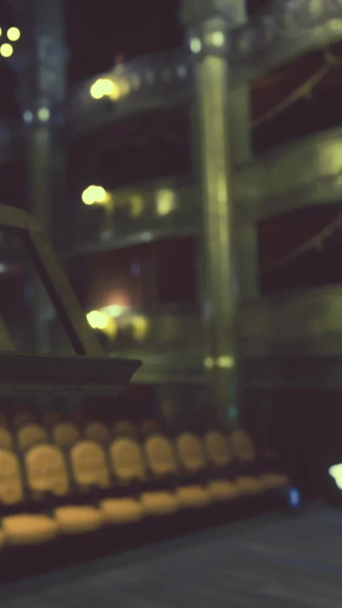 People sit and watch a performance inside a theater during evening hours Stock Footage 331444080