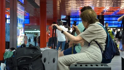 People sit on a bench in a train station building - view from the side Vídeos de archivo 92837253
