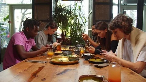 People sit in a cafe, they sit with phones in hands, girl laugh Stock Footage 121936950
