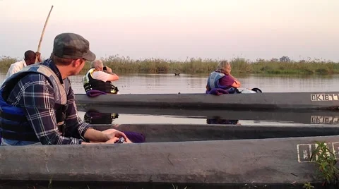 People sit in canoes in hippo infested waters in Botswana. Stock Footage 44103243