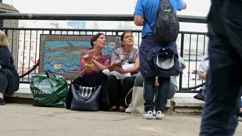 People sit on The Queen's Walk in Queue for Queen lying in state Stock Footage 215930409