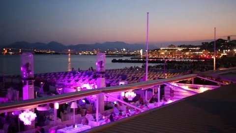 People sit in the restaurant next to the rows of seats overlooking the sea .. Stock Footage 71104453