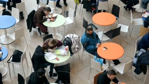 People sit at small round tables in Ocean Plaza mall Stock Footage 71408379