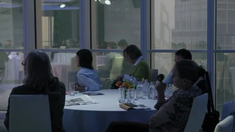 People sit at table near window during E-commerce conference in Mercury tower. Stock Footage 276365541