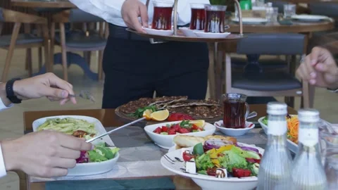 People sit at a table in a restaurant and eat Stock Footage 250098122