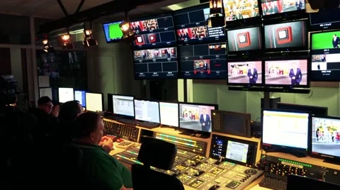 People sit at table in TV studio in front of screen of television Vídeo Stock 64870605