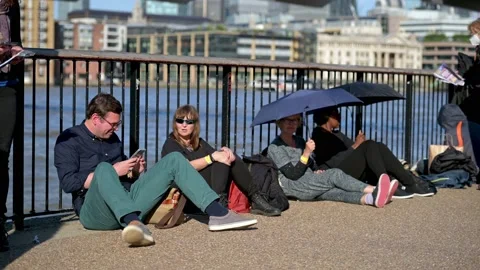 People sit on the Thames riverbank in The Queue to see the Queen lying in sta Stock Footage 211864000
