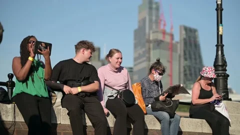 People sit on a wall waiting in The Queue to see the Queen lying in state. Stock Footage 211864113