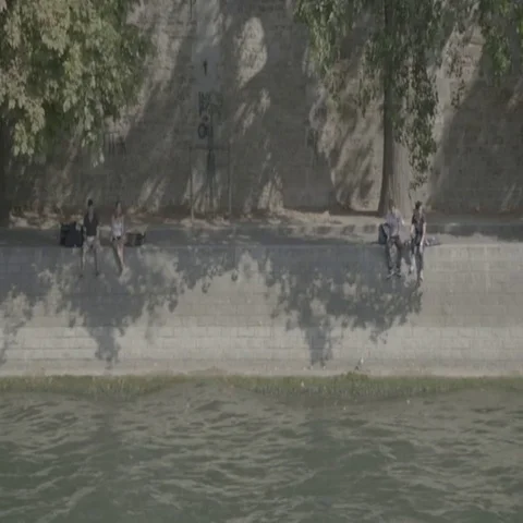 People sitting next to River Seine / Paris, France - 4K Stock Footage 69727156